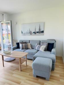 uma sala de estar com um sofá azul e uma mesa de centro em Porto 13 - TRZĘSACZ SUNNY SIDE BALTIC em Trzęsacz