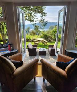 a living room with two couches and a large window at The Ryebeck Hotel in Bowness-on-Windermere