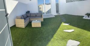 ein Wohnzimmer mit einem Sofa und grünem Gras in der Unterkunft Chambres des délices in Villetelle