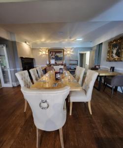 a dining room with a table and white chairs at The Ryebeck Hotel in Bowness-on-Windermere