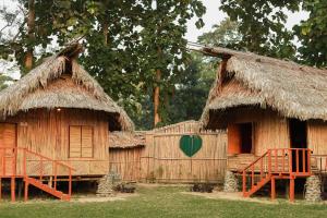 two huts with a green heart painted on them at The Hoollock Heritage in Mariāni