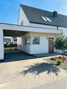 a white house with a garage and a driveway at Porto 13 - TRZĘSACZ SUNNY SIDE BALTIC in Trzęsacz