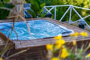 a hot tub in a wooden deck with yellow flowers at Villa Zagara Garden Spectacular Sea View in Taormina in Taormina
