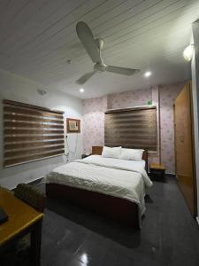 una camera con letto e ventilatore a soffitto di Calawazobia Hotel a Uyo