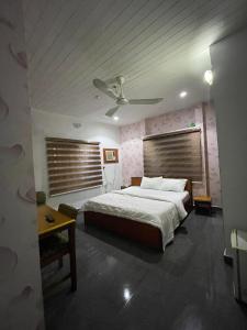 una camera con un grande letto e un soffitto di Calawazobia Hotel a Uyo