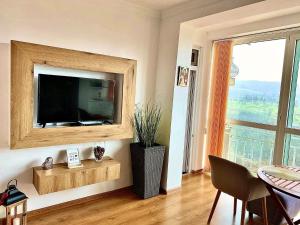 een woonkamer met een flatscreen-tv aan de muur bij Tsarevets panoramic apartments Veliko Tarnovo in Veliko Tŭrnovo