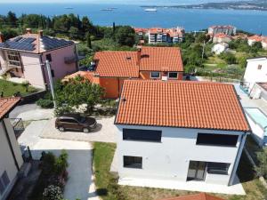 a car parked in front of a white house with red roofs at Hiša Naj in Koper