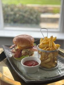 a tray with a sandwich and french fries and sauce at The Ryebeck Hotel in Bowness-on-Windermere