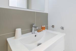 a bathroom with a white sink and a mirror at Dimore delle Zagare Molo in Syracuse