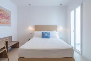 a bedroom with a large bed with a blue pillow on it at Dimore delle Zagare Molo in Syracuse