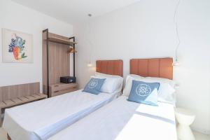 two beds in a hotel room with blue pillows at Dimore delle Zagare Molo in Syracuse