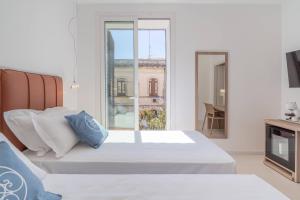 a bedroom with a bed and a large window at Dimore delle Zagare Molo in Syracuse