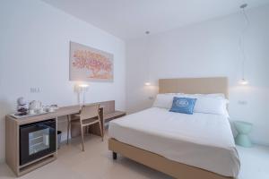 a bedroom with a bed and a desk with a television at Dimore delle Zagare Molo in Syracuse
