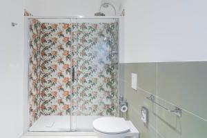 a bathroom with a shower curtain with a toilet at Dimore delle Zagare Molo in Syracuse