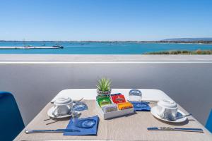 a table with a tray of food and a view of the water at Dimore delle Zagare Molo in Syracuse