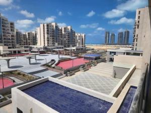 vistas a un edificio con piscina y pistas de tenis en داون تاون العلمين الجديدة en ‘Ezbet `Abd el-Ḥamîd