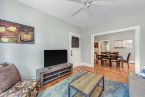 a living room with a couch and a flat screen tv at 2e Tower Grove Getaway in Richmond Heights