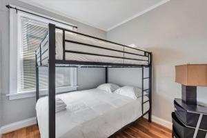 a bedroom with a bunk bed with white sheets at 2e Tower Grove Getaway in Richmond Heights