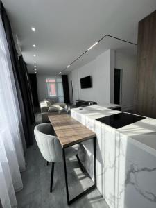 cocina y sala de estar con barra y mesa en Lux в ЖК TALAN LIFE от Bi Group, en Atyraū
