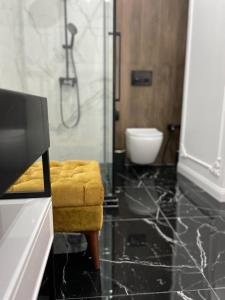 baño con taburete amarillo y ducha en Lux в ЖК TALAN LIFE от Bi Group, en Atyraū