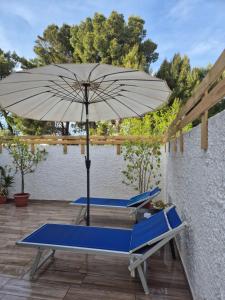 un patio con due sedie e un ombrellone di That's amore Brindisi beach a Brindisi