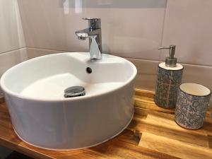 a bathroom with a white sink on a wooden floor at La loge des Salinières in Bordeaux +17 photos