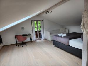 a bedroom with a bed and a desk and a window at Ferienhaus Bad Feilbach in Bad Feilnbach
