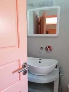 a bathroom with a white sink and a mirror at Vocamvilia Apartments in Kamari +131 photos