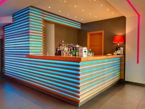 eine farbenfrohe Bar in einem Hotelzimmer mit gestreifter Wand in der Unterkunft Hotel Cleofe in Caorle