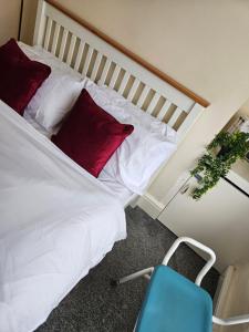 - une chambre avec un lit doté d'oreillers rouges et d'une chaise bleue dans l'établissement Surefest, à Liverpool