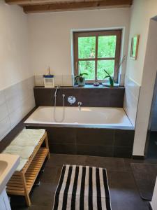 a large bathroom with a tub and a window at Ferienhaus Bad Feilbach in Bad Feilnbach