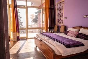 1 dormitorio con cama y ventana grande en Dew Drops Homestay en Nainital