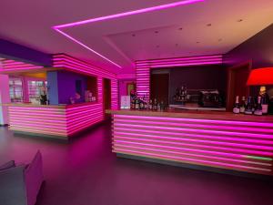 a bar with purple lighting in a room at Eco Hotel Cleofe in Caorle