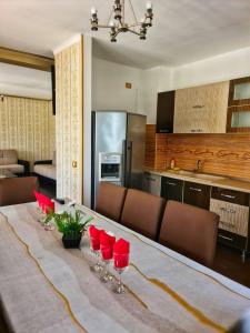 uma cozinha com uma mesa com copos de vinho tinto em Silver em Hunedoara