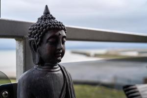 a statue of a buddha in front of a fence at 6 Mariners Point in Hartlepool