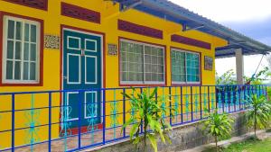 a yellow and blue house with a blue railing at Las Catalinas Ecológicas (El Maizal) in Antón