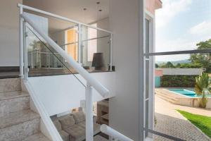 a white staircase in a house with a pool at Espaco Bom Viver in Jundiaí