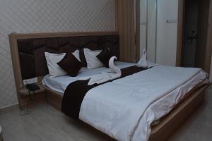 una camera da letto con un grande letto con due cigni sopra di Hotel Shree Om a Jumri TilaiyÄ