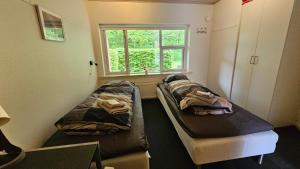 2 camas en una habitación con ventana en Gudum Park, en Lemvig