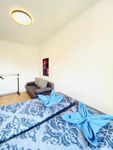 1 dormitorio con cama con sábanas azules y sofá en Family House in Am Schöpfwerk area, en Viena