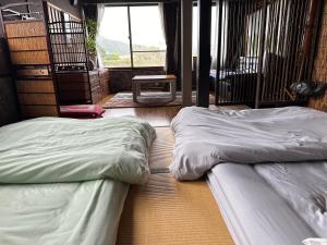 two beds sitting on the floor in a room at ゲストハウス れんげ苑 in Shimosato