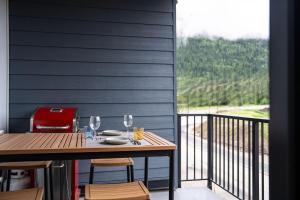 een tafel en stoelen op een balkon met een raam bij Summit Views Condo by Revelstoke Vacations in Revelstoke