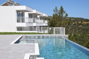 a villa with a swimming pool and a house at AKAMAS THRONE APARTMENTS in Neo Chorio
