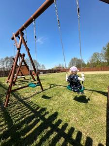 a young child on a swing at a park at Fotuso House in Majdany Wielkie