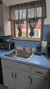 un comptoir de cuisine avec un évier et une fenêtre dans l'établissement Ambiance - KING BED Cabin Loft & Fireplace, à Tobyhanna