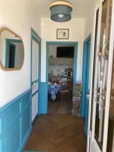 a hallway with a blue door and a dining room at Les chambres du Phare - 3 chambres in Le Port-des-Barques