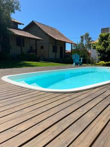 una piscina en una terraza junto a una casa en Rosa Olas Cabanas en Praia do Rosa