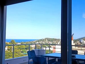 a view of the ocean from a balcony with a table and chairs at Petros House Artemis - Near the Airport in Artemida