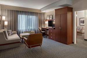 a hotel room with a desk and a living room at Courtyard Long Beach Airport in Long Beach