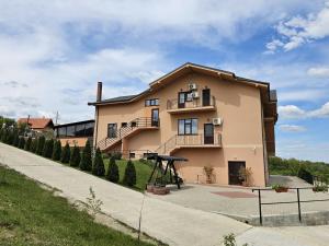 una casa grande con un parque infantil delante de ella en Casa Galu, en Nicoreşti